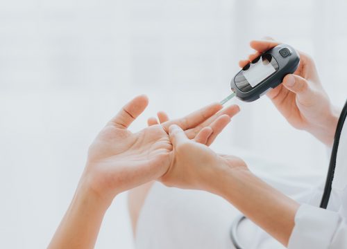 Persons hand getting diabetes blood test and discussing Diabetes Treatment in Fullerton CA doctors office