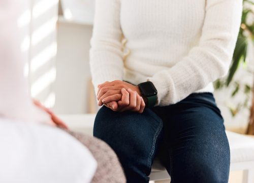 Woman sitting on exam table talking to a doctor